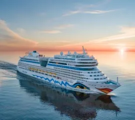 Die AIDAstella bei Sonnenuntergang auf hoher See in der Seitenansicht.