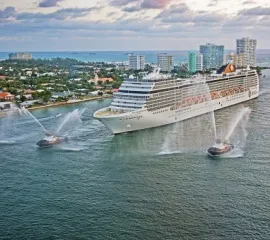 Die MSC Orchestra in Seitenansicht im Hafen von Port Lauderdale mit kleineren Begleitbooten. Copyright: MSC Cruises.