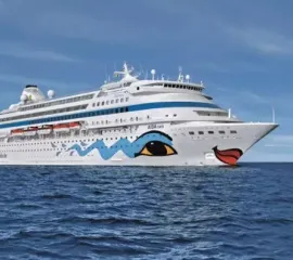 Die AIDAcara, ein ehemaliges Schiff von AIDA Cruises, in Seitenansicht auf dem offenen Meer.