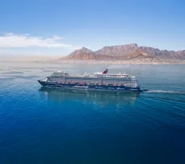 Die <i>Mein Schiff 2</i> in der Seitenansicht, fährt durch das Meer an der Küste von Kapstadt.