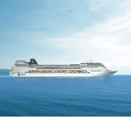 Die MSC Sinfonia in Seitenansicht auf dem offenen Meer. Im Hintergrund ist eine Insel erkennbar. Copright: MSC Cruises.