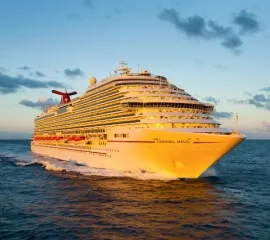 Die Carnival Magic auf hoher See von Vorne. Das Schiff wird von einem sanften Licht angeleuchtet.