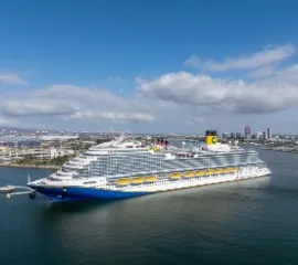 Das elegante Carnival Firenze Kreuzfahrtschiff liegt majestätisch geankert mit Blick auf die Stadt-Skyline.