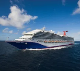 Die Carnival Valor in Seitenansicht auf dem offenen Meer. Die einzelnen Decks sind gut zu unterscheiden.