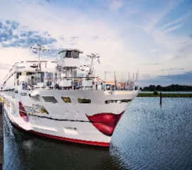 Ein buntes Schiff von A-ROSA am Tag an einem Kai.