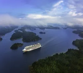 Das Schiff Norwegian Getaway gleitet im tiefblauen Wasser.