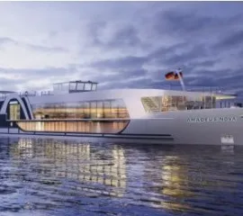 Die AMADEUS Nova auf dem Wasser am Abend hell beleuchtet.