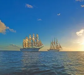 Star Clipper und Star Flyer auf hoher See mit weitem Horizont bei Sonnenuntergang.