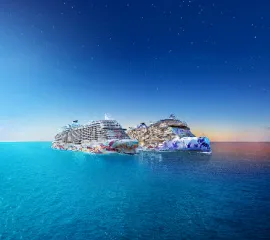 Zwei festlich beleuchtete Kreuzfahrtschiffe der Norwegian Cruise Line fahren nebeneinander auf dem ruhigen, dunkelblauen Ozean unter einem klaren Sternenhimmel.