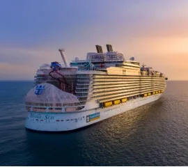 Die Wonder of the Seas schippert bei Abendröte über das Meer.