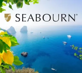 Seabourn-Logo, im Hintergrund kleinere Inseln mit Riffen bei klarem Himmel.