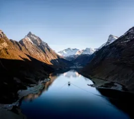 Ein Schiff von Havila Voyages in einem norwegischen Fjord.