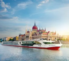 Ein Schiff der nicko cruises Flotte fährt auf der Donau am Parlament in Budapest vorbei.