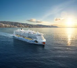 Die AIDAperla, wie sie durch die weiten des Meers pflügt bei Sonnenuntergang.