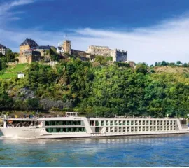 Flusskreuzfahrtschiff von Scenic vor Burglandschaften am Fluss.