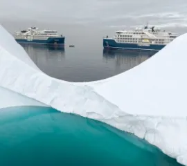 Die SH Diana und SH Vega in einem Eismeer hinter einem Gletscher.