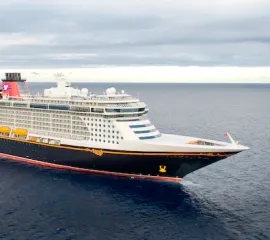 Disney Cruise Line FAQ - Die Disney Fantasy auf hoher See an einem bewölkten Tag.