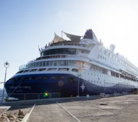 Die Celestyal Discovery an einem Hafen fotografiert von Hinten.