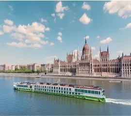 Das Kreuzfahrtschiff Amethyst 1 gleitet im tiefblauen Wasser und im Hintergrund ist die Stadt zu sehen.