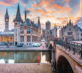 Die idyllische Stadt Gent mit einem Kanal und einer Brücke, die in die historische Altstadt führt.