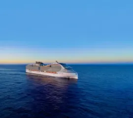 Die MSC World Asia auf hoher See. Die Seitenlage zeigt die charakteristische Architektur der World Class mit einer Wellenform.