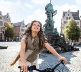 Eine Frau auf einem A-ROSA Fahrrad schaut sich am Grote Markt in Antwerpen, Belgien um.