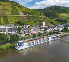Die MS Antonio Bellucci liegt vor einem Weinort mit steilen Weinbergen am Flussufer.