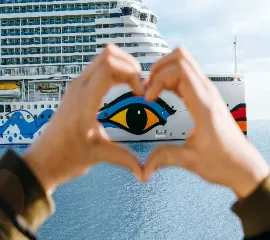 Zwei Hände, die um das AIDA Logo ein Herz formen.