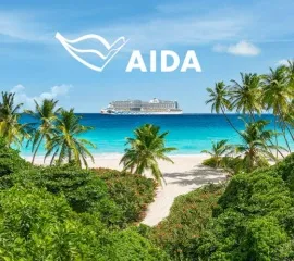 AIDAperla am Horizont in der Karibik, direkt vor einer mit Palmen bewachsenen Insel.