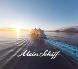 Heckansicht von Mein Schiff Flow auf dem Meer im Sonnenuntergang. Darunter der Mein Schiff Schriftzug in weiß.