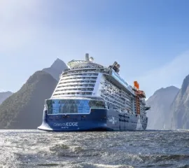 Das Schiff Celebrity Edge von Celebrity Cruises gleitet im tiefblauen Wasser.