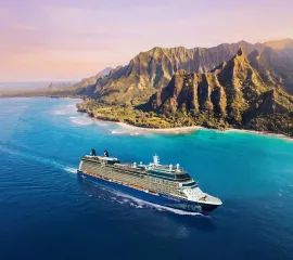 Die Celebrity Equinox von Celebrity Cruises fährt entlang einer beeindruckenden felsigen Insel.