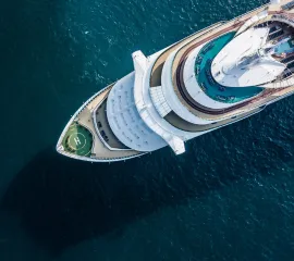 Ein Kreuzfahrtschiff von oben auf dem Meer.