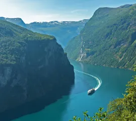 Ein Kreuzfahrtschiff fährt durch einen norwegischen Fjord.