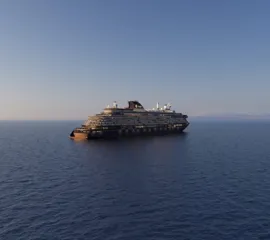 Luxuskreuzfahrtschiff EXPLORA VI von Explora Journeys auf ruhiger See im Abendlicht.