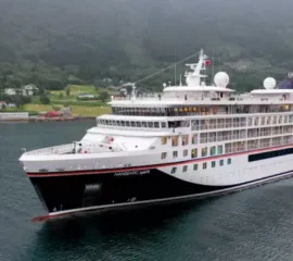 Die HANSEATIC spirit fährt ein einem verregneten Tag entlang der norwegischen Küste.
