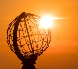 Die Nordkap-Kugel im Sonnenuntergang symbolisch für eine Weltreisekreuzfahrt.