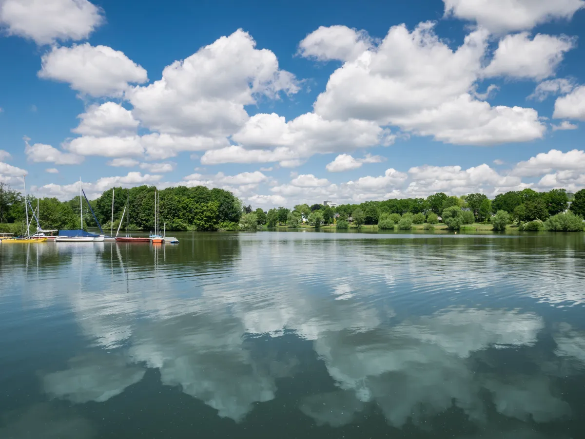 Der Aasee in Ibbenbüren – Naherholungsgebiet mit Segelsport und Beach-Zone Segelboote am Ibbenbürener Aasee bei sommerlichem Wetter mit spiegelnden Wolken