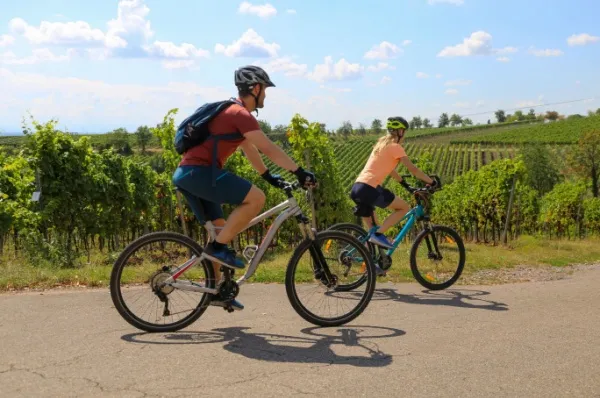 Zwei Menschen radeln auf e-Bikes durch Frankreich: Sie haben die Radreise Kreuzfahrt von A-ROSA gebucht.