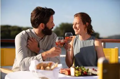 Ein Paar sitzt an Deck eines A-ROSA Schiffs und genießt ein Dinner.