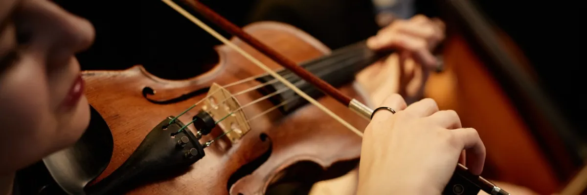 Eine Frau spielt Geige auf einem der A-ROSA Schiff im Rahmen einer musikalischen Kreuzfahrt.