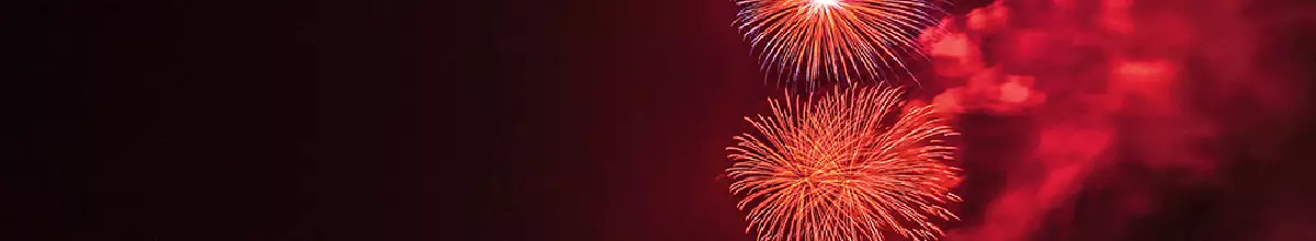 In der Nacht erstrahlt ein rotes Feuerwerk am Himmel.