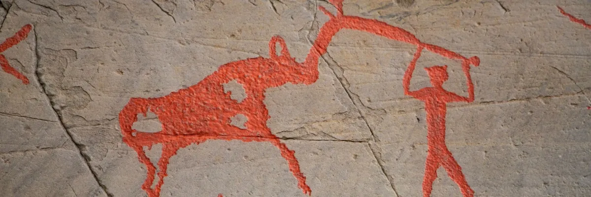 Eine Höhlenmalerei mit einem Person, die ein Tier bekämpft. Auf A-ROSA Kunst-Kreuzfahrten erfahren Sie mehr über historische Bilder.