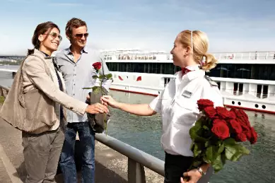Eine Mitarbeiterin von A-ROSA begrüßt die Passagiere.