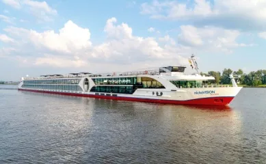 Das elegante Flussschiff nickoVISION der Reederei nicko cruises gleitet durch einen Fluss.