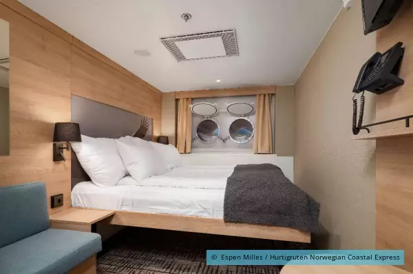 Zu sehen ist ein Bett auf der MS Nordkapp in seiner Kabine.