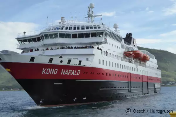 Das Kreuzfahrtschiff MS Kong Harald von Hurtigruten in der Frontansicht in einem norwegischen Fjord.