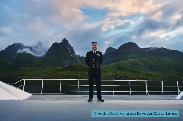 Der Kapitän steht an Bord der MS Polarlys von Hurtigruten An Bord der MS Polarlys steht der Kapität der Besatzung Hurtigruten vor wunderschöner Natur.