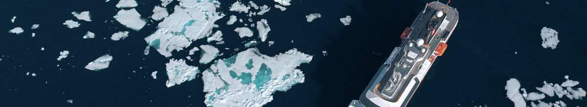 Die MS Fram fährt durch Poolepynten in Svalbard und ist von Eisbergen umgeben.