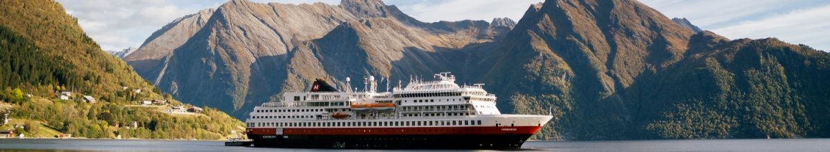 Die MS Finnmarken in Hjørundfjord mit Bergpanorama im Hintergrund.